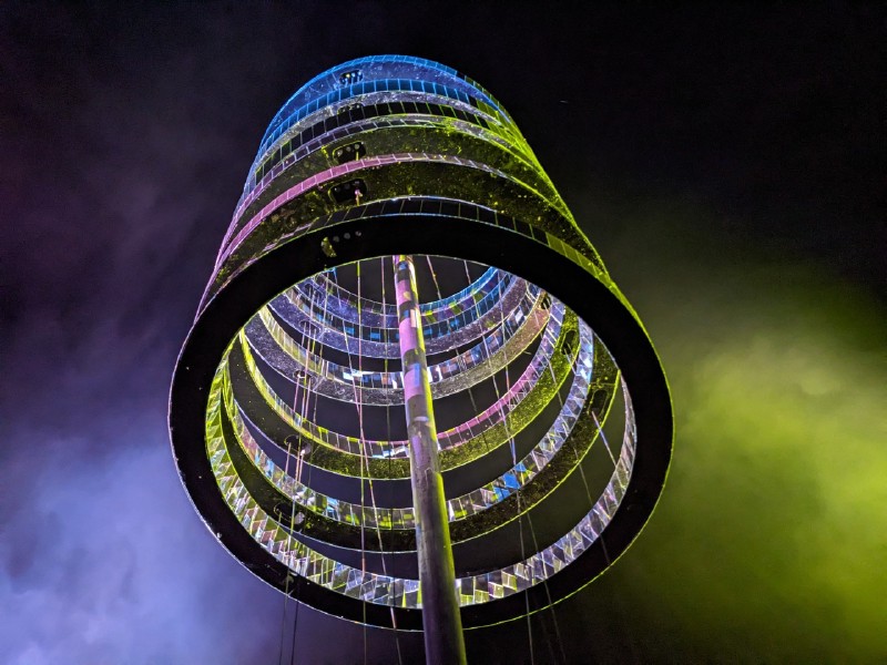 Bunt beleuchtete Spirale aus Metall und Glas bei Nacht