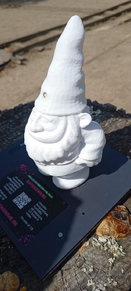 Ein kleiner, weißer Zwerg aus 3D-gedrucktem Plastik. Auf dem Sockel eine Plakette die erklärt, dass er ein Sensor ist der Daten sammelt.