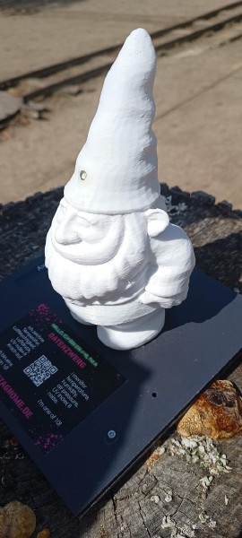 Ein kleiner, weißer Zwerg aus 3D-gedrucktem Plastik. Auf dem Sockel eine Plakette die erklärt, dass er ein Sensor ist der Daten sammelt.